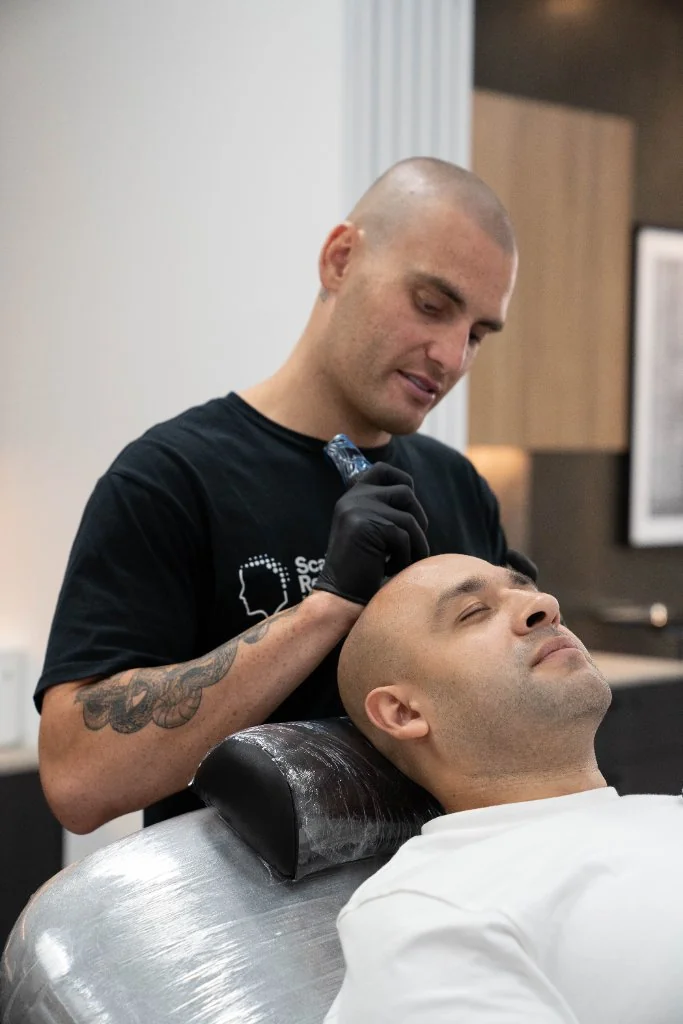 Jackson Cross performing scalp micropigmentation in the Wollongong studio